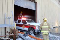 Firefighter on truck backed inside building