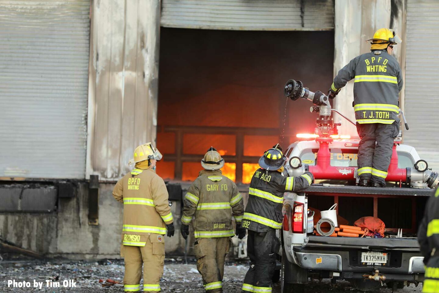 Firefighters prepare to attack fire through roll-down doors