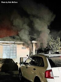 Smoke shoots from the interior of the home