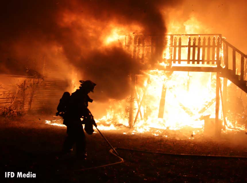 Firefighter silhouetted by flames at fire in Indiana