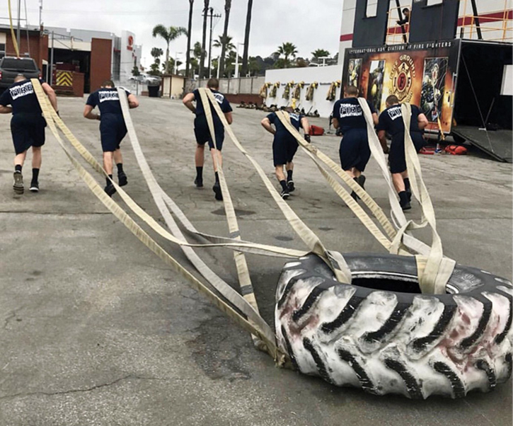 Firefighters pulling a giant tire