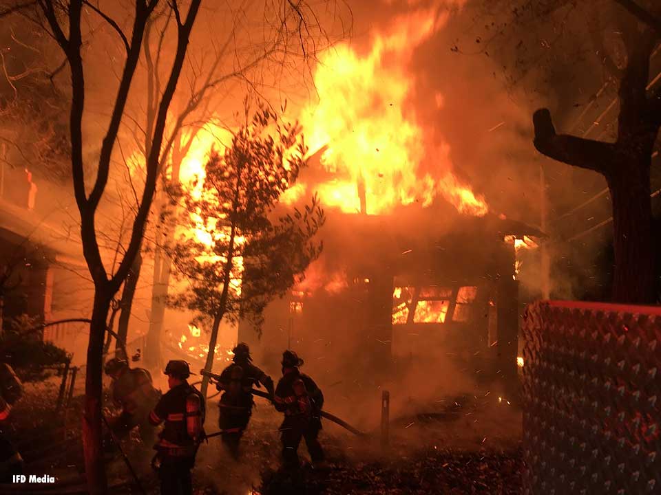 Raging fire in Indianapolis with firefighters pulling hoselines