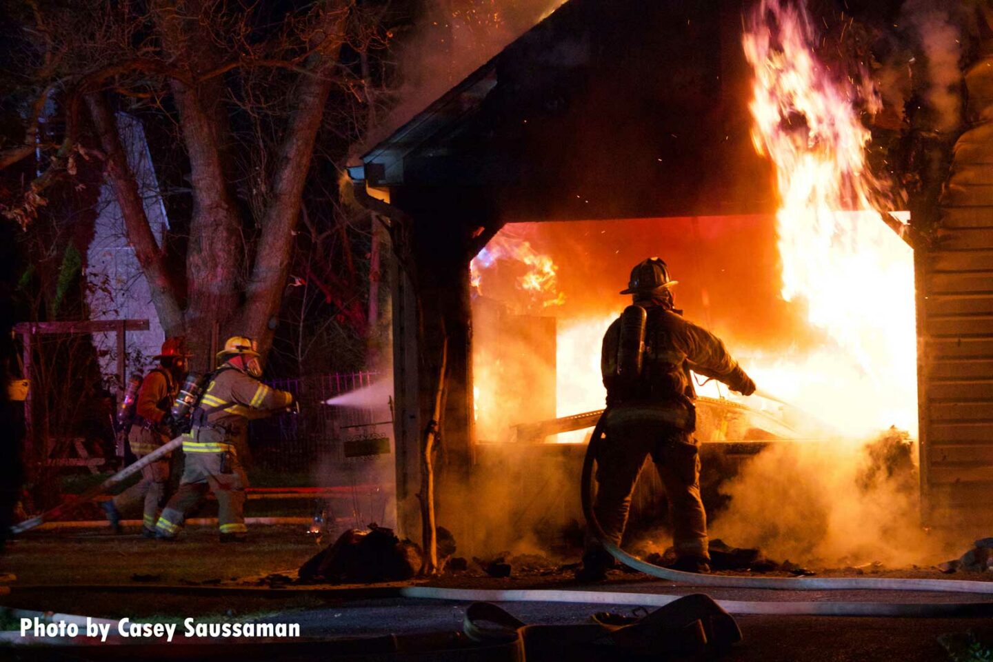 Firefighters put water on flames shooting from a garage in Pennsylvania