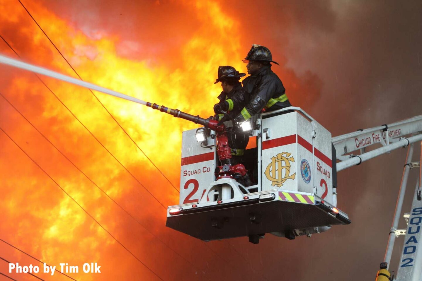 Chicago firefighters of Squad 2 in a bucket train water on huge flames