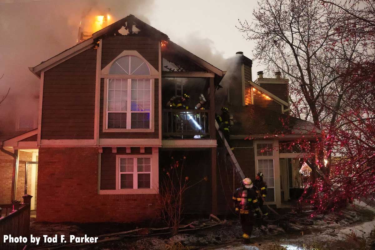 Firefighters stretch lines on apartment fire