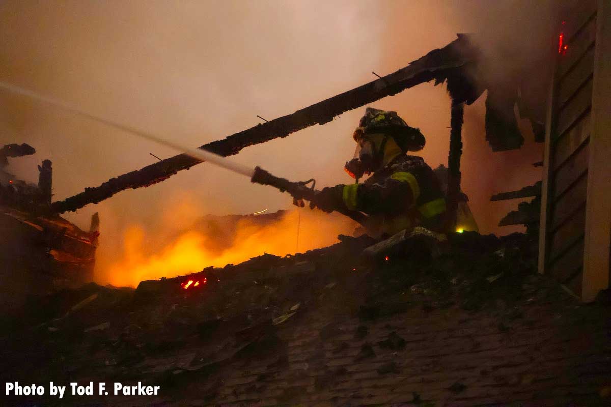 A firefighter pouring water on the flames