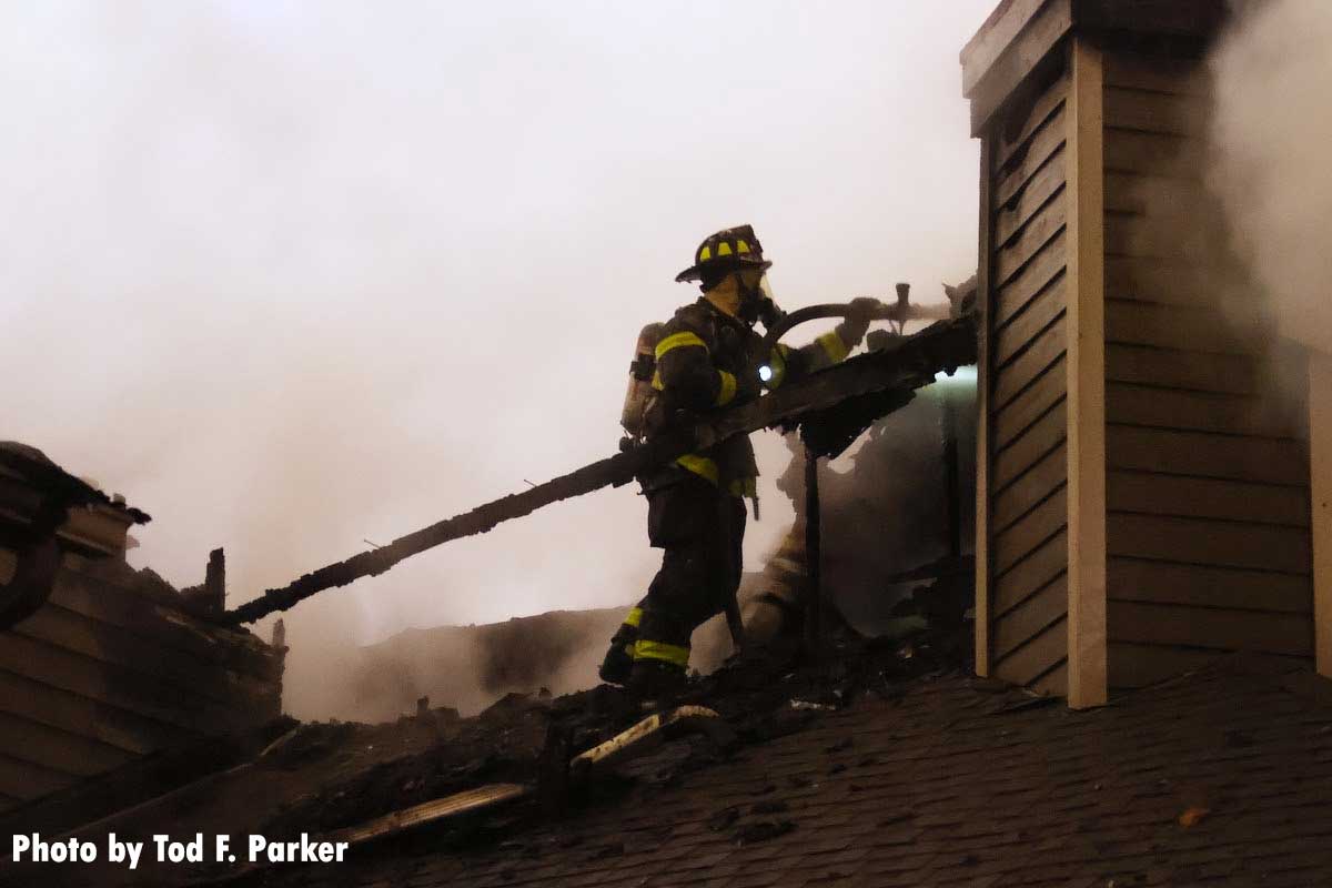 Firefighter with a hoseline on the roof