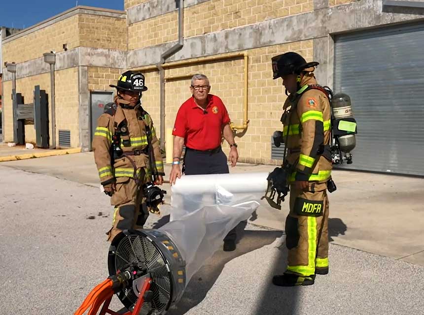 Bill Gustin and firefighters with a plastic duct and fan