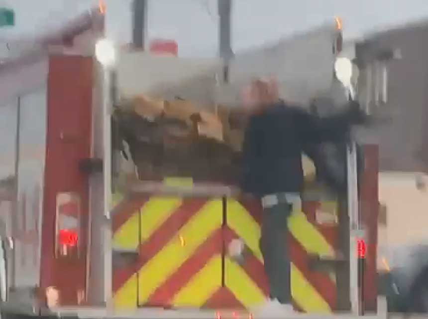 Woman riding on back of Indianapolis fire truck