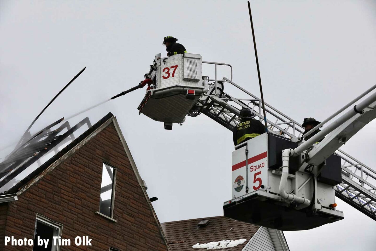 Chicago firefighters operate from two buckets at a residential fire