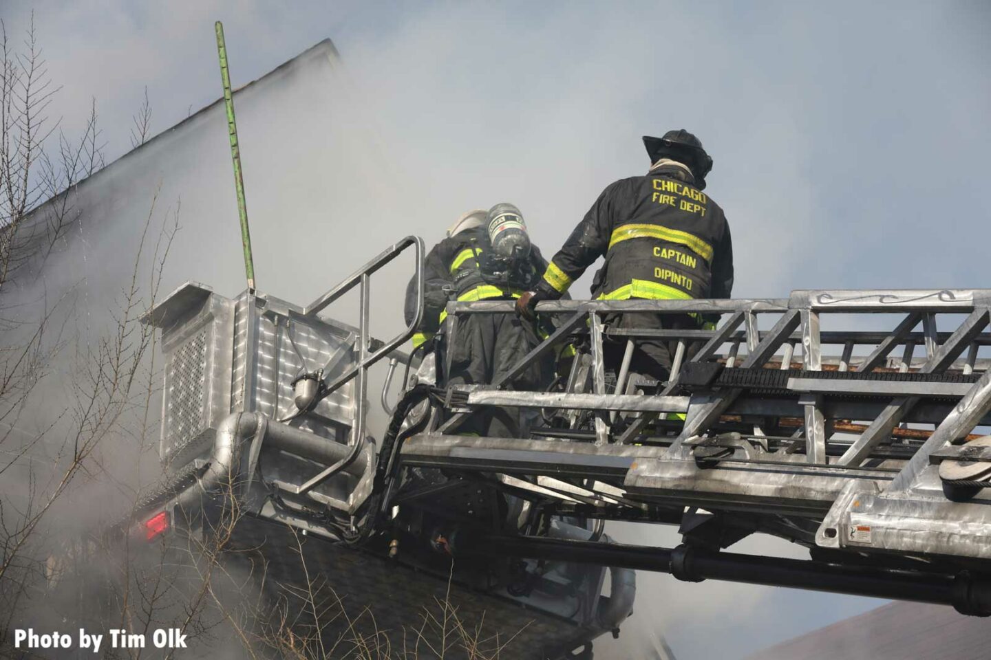 Chicago firefighters partly enveloped by smoke in a tower ladder bucket