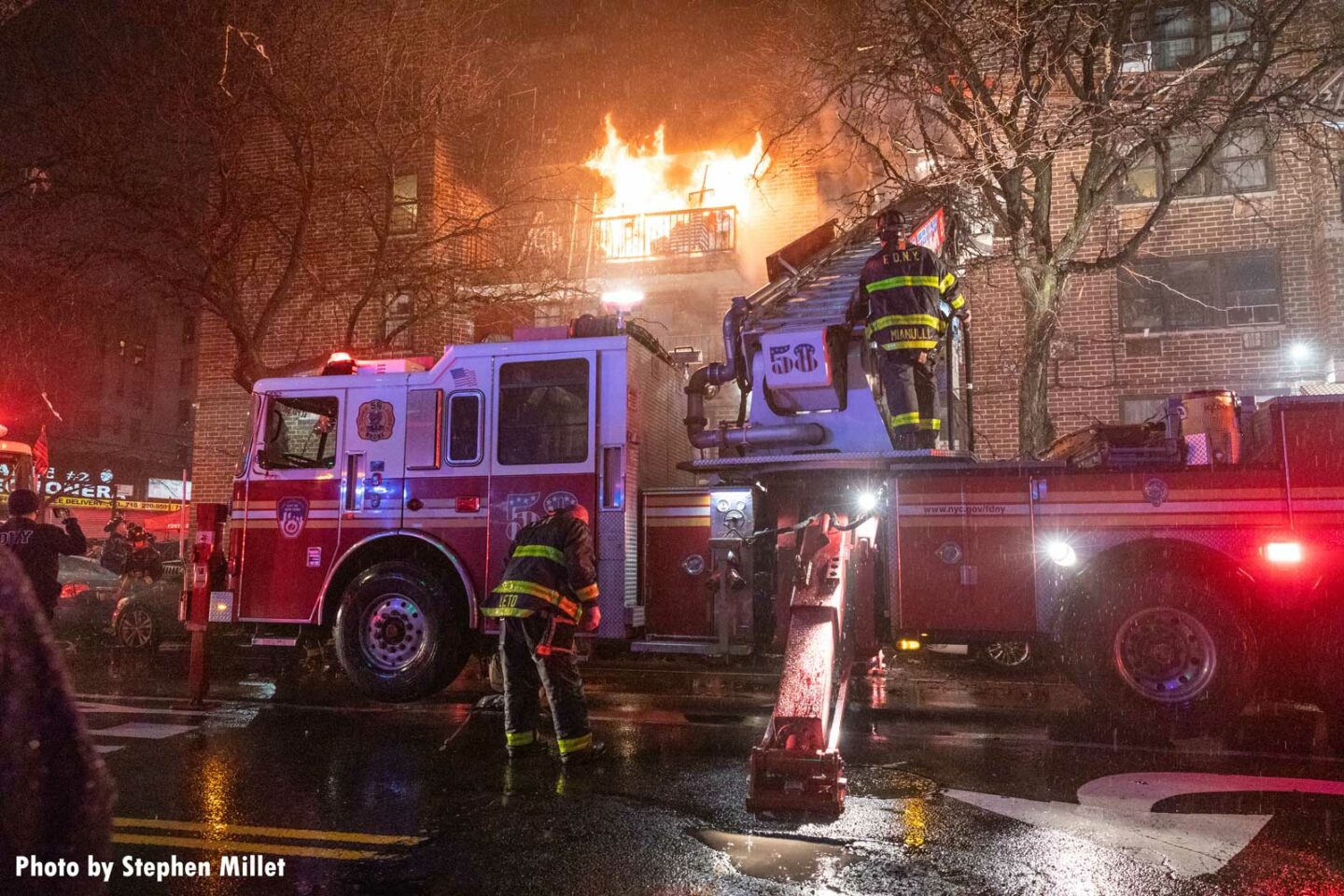 Flames raging from a multiple dwelling in the Bronx as FDNY members work