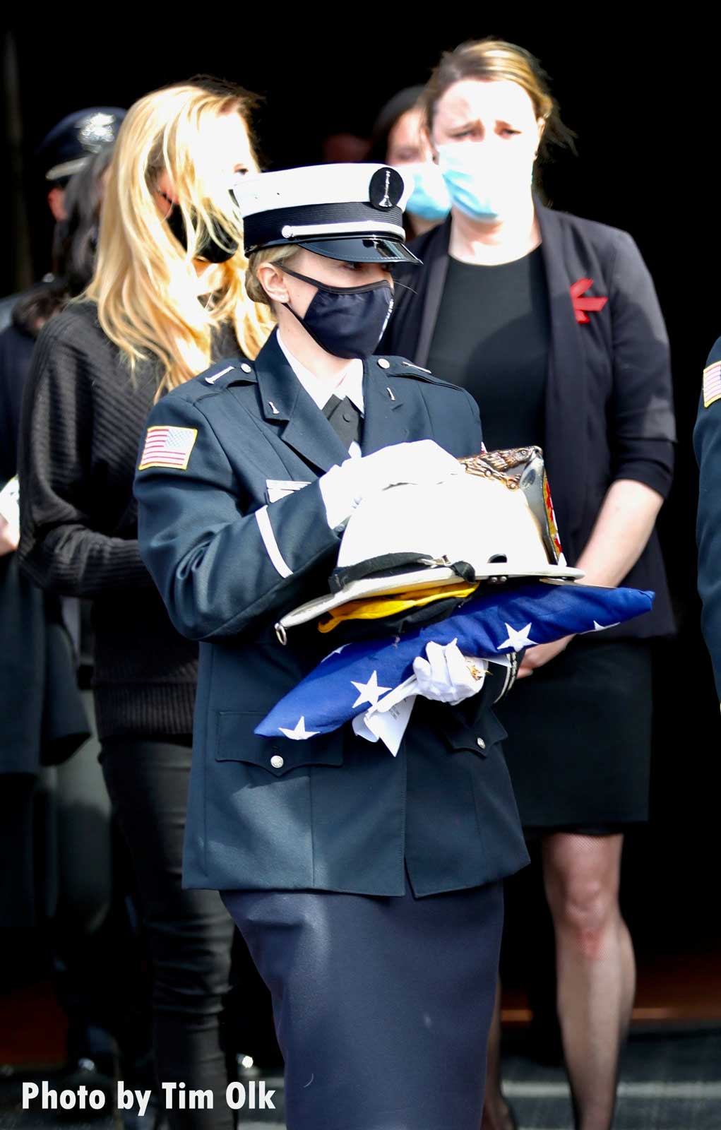 Firefighter bearing helmet and flag at Al Schlick funeral