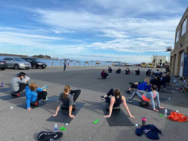 Female firefighters perform glute figure-4 stretch