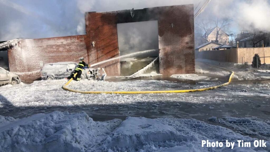 Firefighter puts water stream into collapse building in Hammond