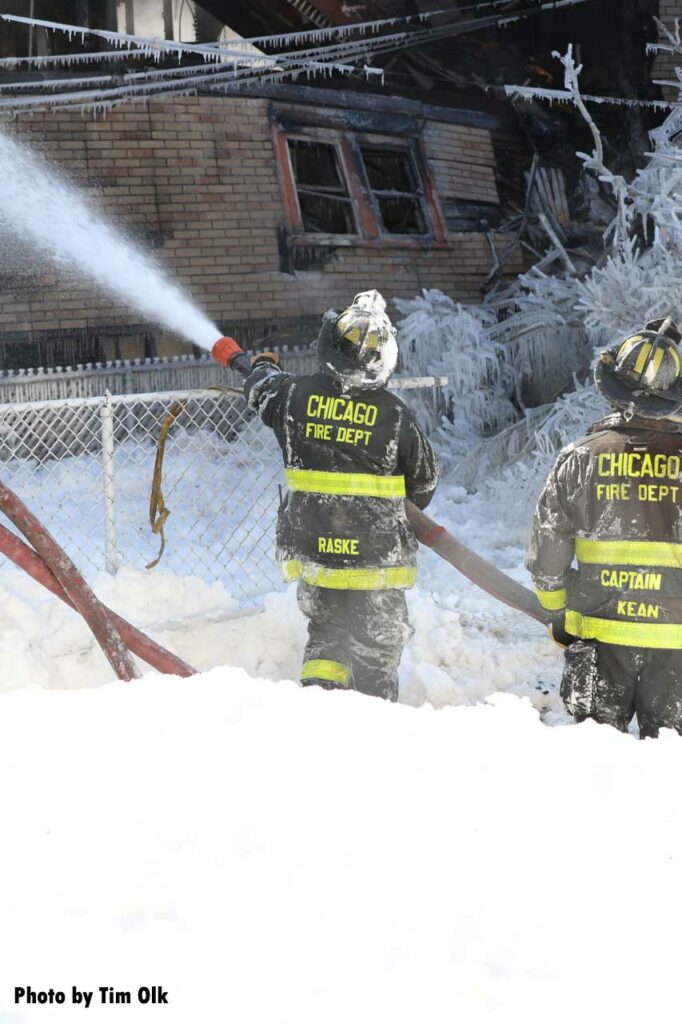 Chicago firefighters with a hoseline in the snow