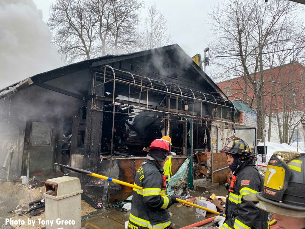 Firefighters outside the burned-out hulk of the building in Monsey