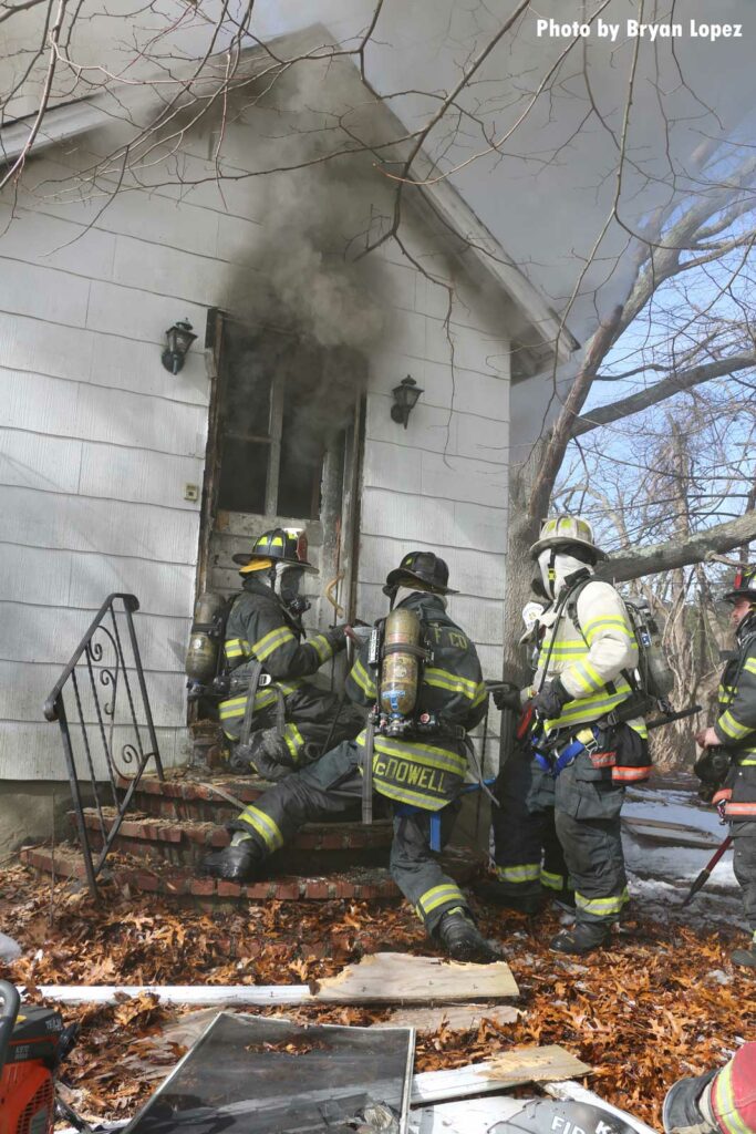 Another view of firefighters working at the scene of the Long Island house fire