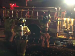 Firefighters taking a ladder off a truck