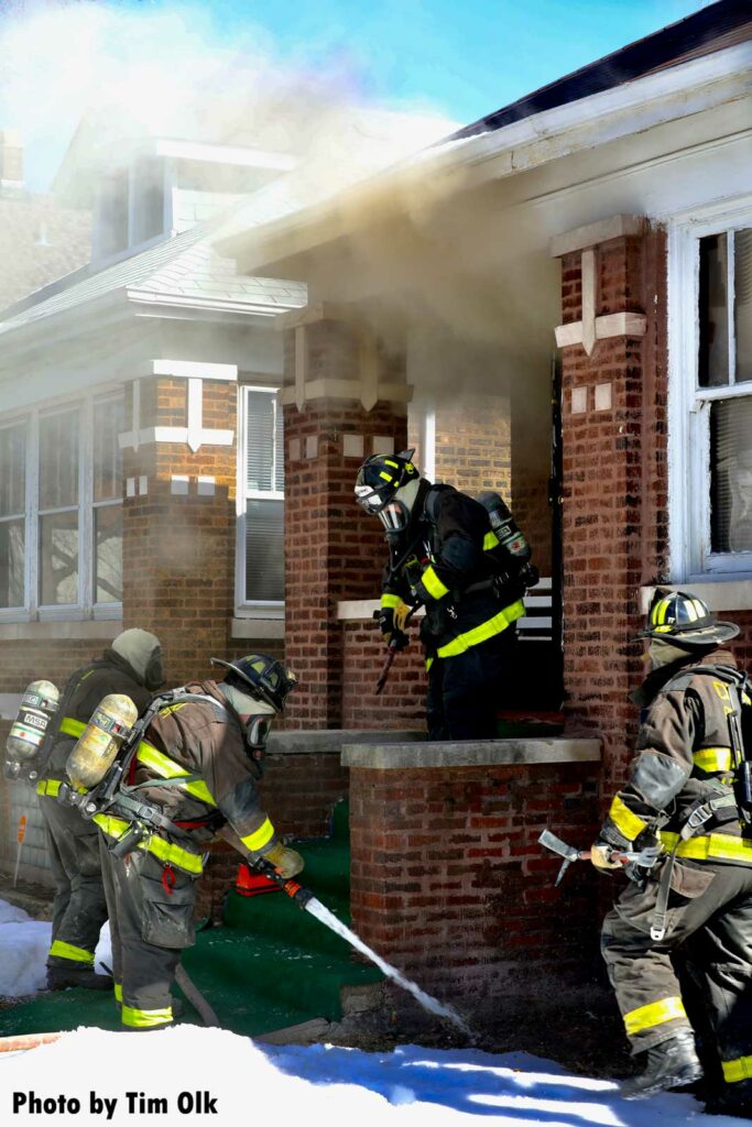 Firefighter tests flow of handline prior to making interior push at house fire