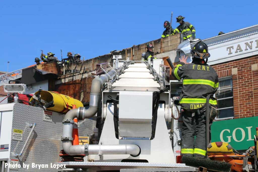 FDNY members working on the roof at a fire in Queens