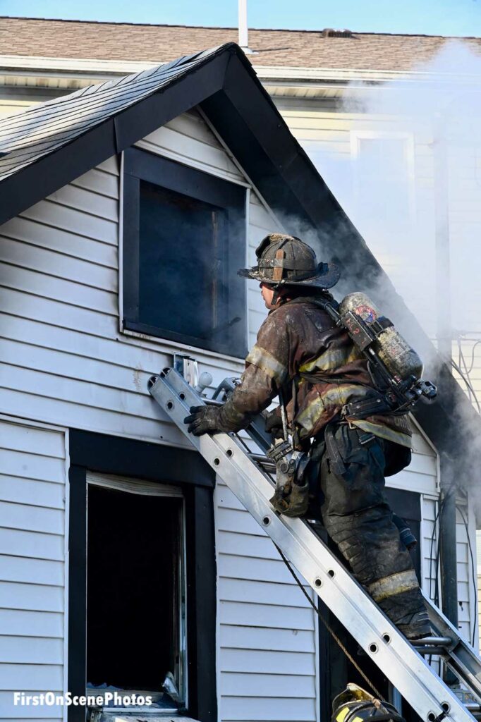 Firefighter climbs ladder at scene of fire