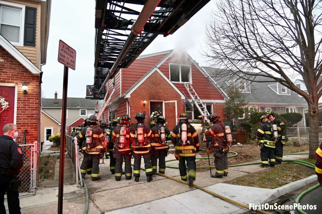 Aerial device and firefighters at scene of house fire