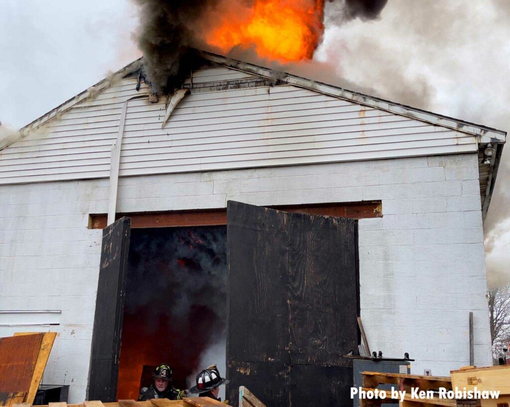 Flames shoot from the roof as firefighters respond to a second-alarm fire in Woburn, Massachusetts