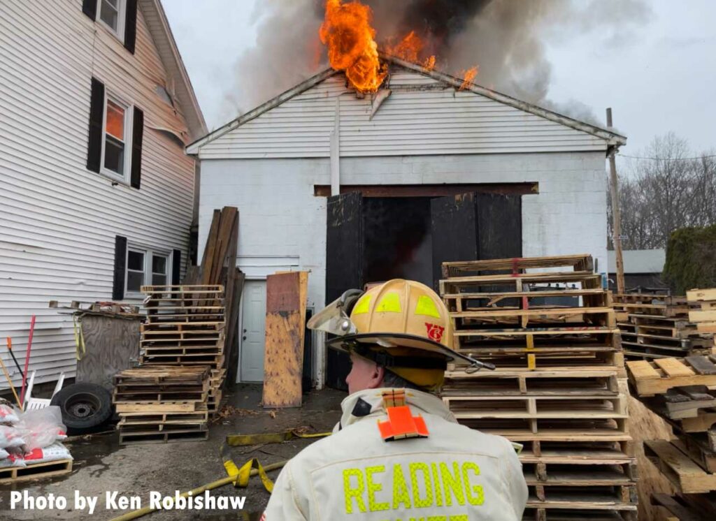 Reading firefighter with the building in the background and fire showing from the roof