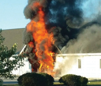 The fire before fire department arrival. Bystanders reported that a truck had crashed into the building, but there was no indication that a truck was inside and there were no skid marks or other indications of an accident.