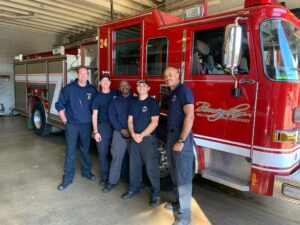 A group of firefighters and a fire truck