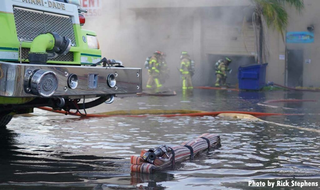 Miami-Dade fire apparatus with hose bundle in a pool of water