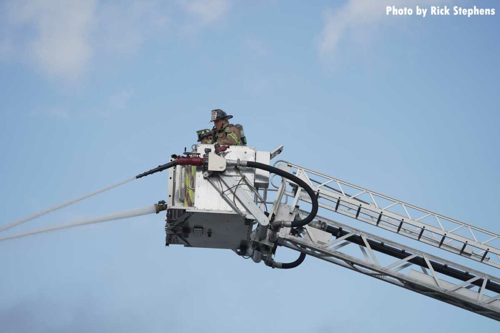 Firefighters in the tower ladder bucket with master streams