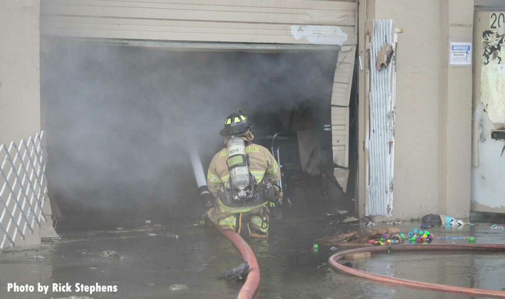 Firefighter puts a portable master stream inside the building