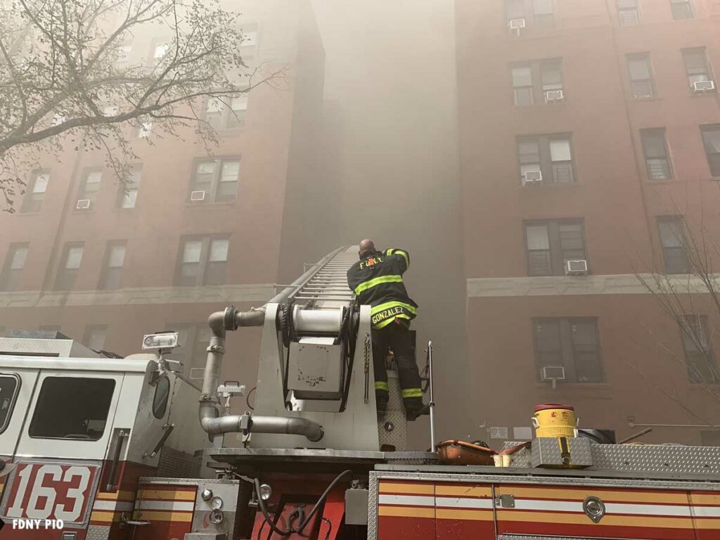 FDNY firefighter and aerial device positioned in recess in building