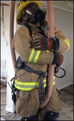 Firefighter hanging on hose ready to be pulled up