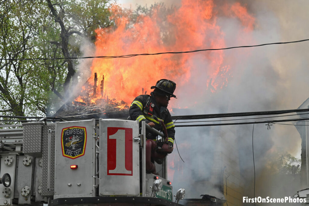 Firefighter in the bucket of Hempstead Fire Department Truck 1 as flames roar behind him