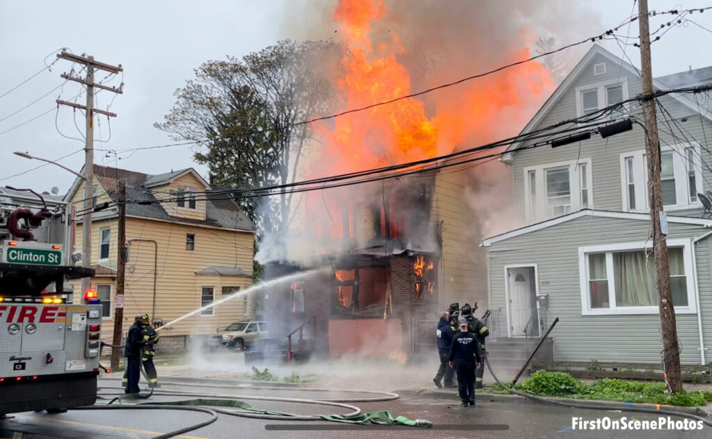 Firefighter puts an exterior stream on a fire raging in an abandoned home