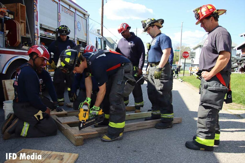 Firefighters use a drill to put together the shore support system