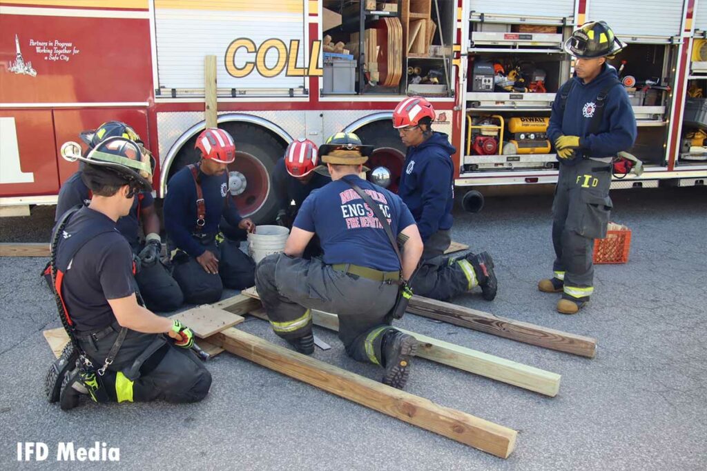 Firefighters work on the shore with the rescue truck in the background