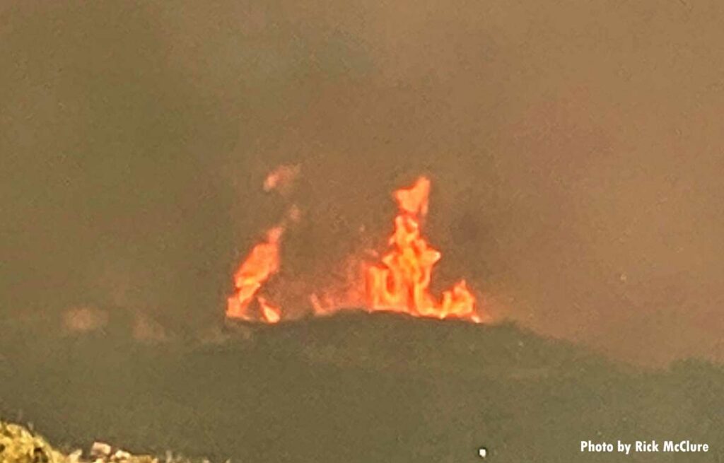 Flames from the Palisades Fire glimpsed in the distance