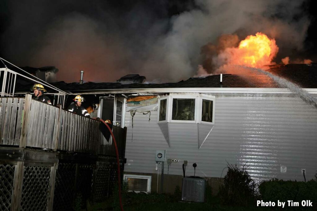 Flames roar from roof as exterior hosestream hits it