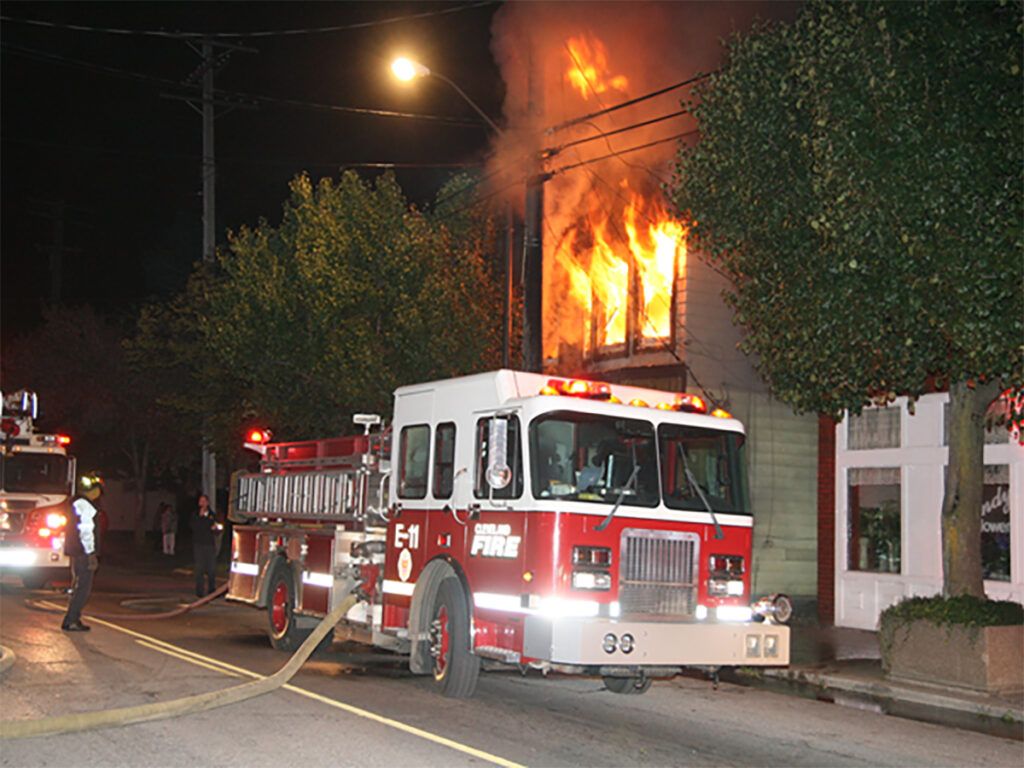 Flames rise behind a fire apparatus