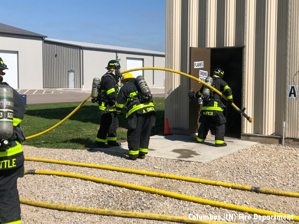 Firefighters stretch a line inside the training building