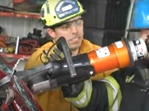 Firefighters using hydraulic cutting tools during extrication