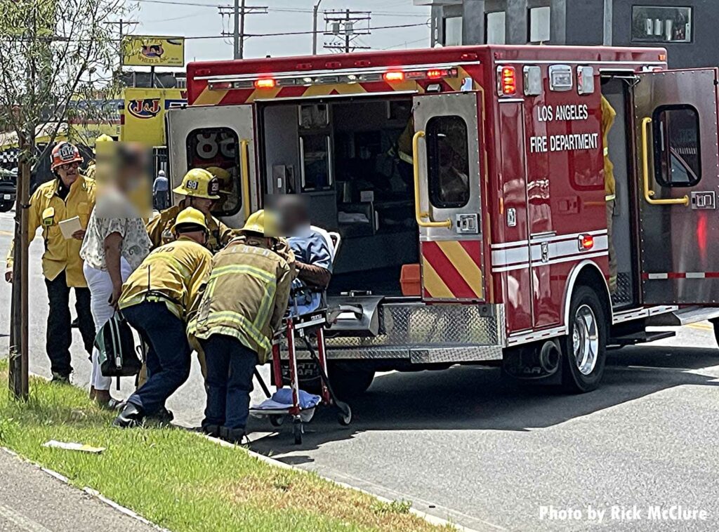 Firefighters load a patient into an ambulance