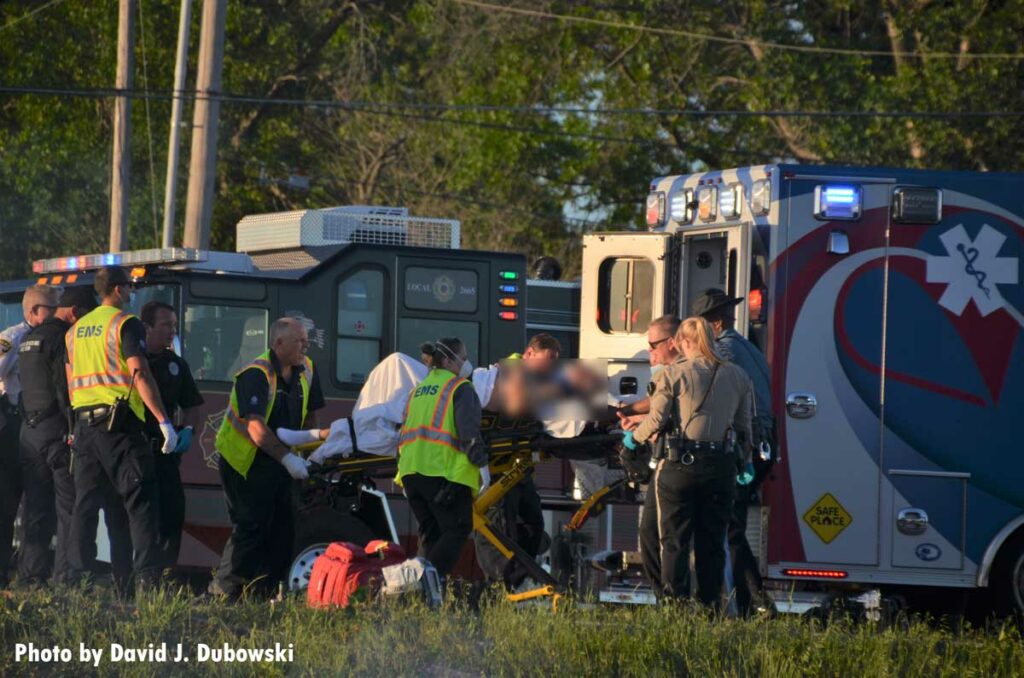 Firefighters load a patient onto an ambulance