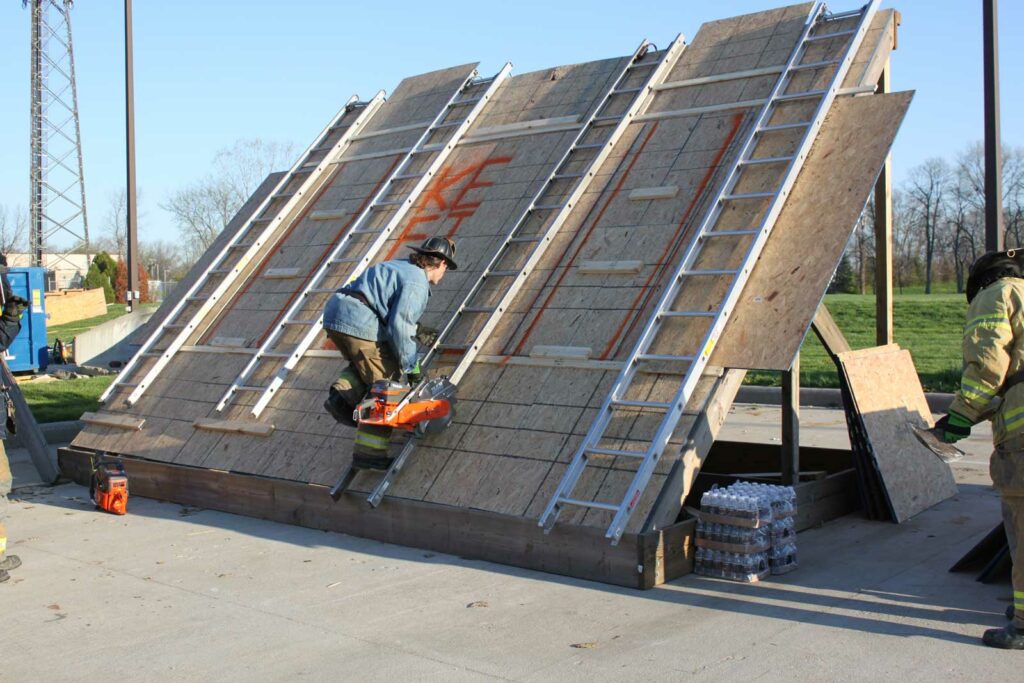 Firefighter using multiple ladders for vertical ventilation access