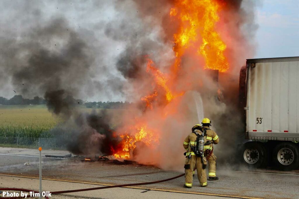 Flames rip through a semi truck as firefighters apply water