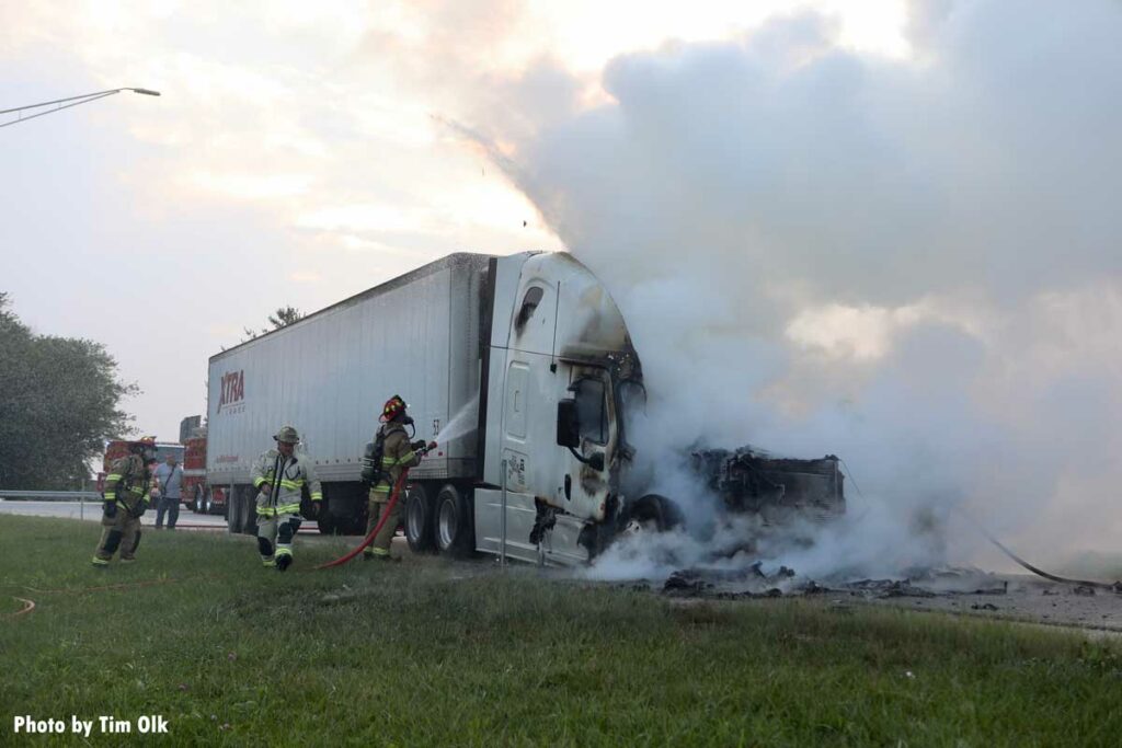 Firefighters at a semi fire put water between the cab and the trailer